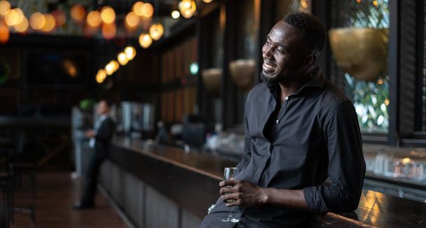Portret van een zelfverzekerde Afro-Amerikaanse zakenman in de nachtclub.  - Foto, afbeelding