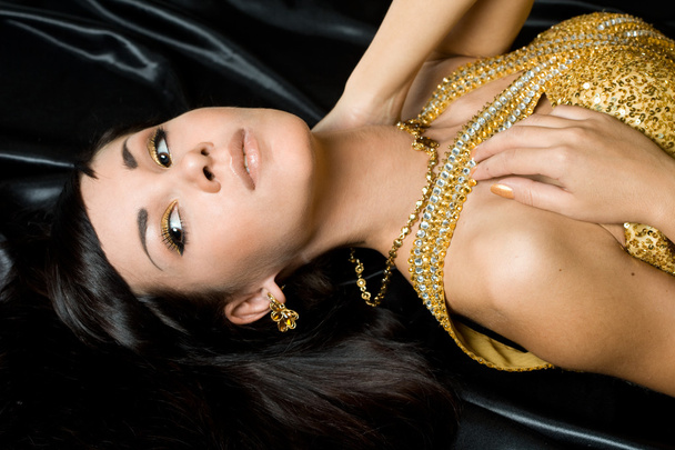 Beautiful fashionable woman in golden dress - Valokuva, kuva
