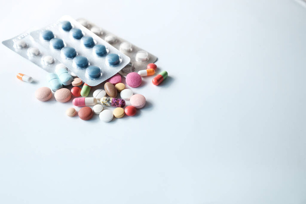 primo piano di pillole colorate versando su sfondo bianco  - Foto, immagini