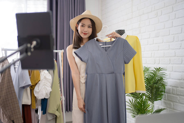 Aasialainen nainen myy vaatteita verkossa pesee vaatteita kaikilla sosiaalisen median kanavilla. - Valokuva, kuva