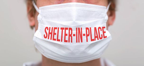 Shelter in place theme with person wearing a protective face mask - Zdjęcie, obraz