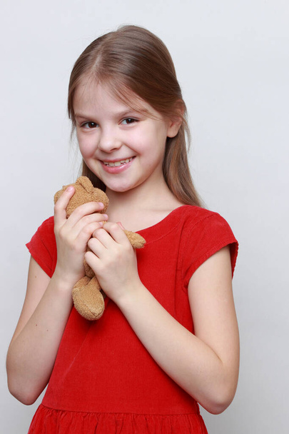 Adorable kid is holding lovely teddy bear toy. - 写真・画像
