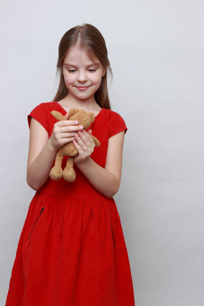 Adorable kid is holding lovely teddy bear toy. - Foto, Imagem