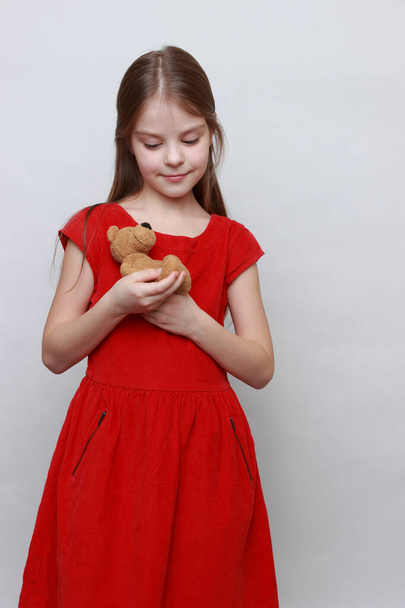 Adorable kid is holding lovely teddy bear toy. - Foto, imagen