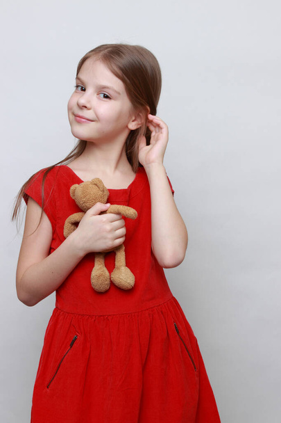 Adorable kid is holding lovely teddy bear toy. - Фото, изображение