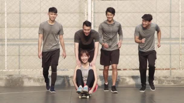 jóvenes asiático amigos tener divertido con un skateboard al aire libre - Imágenes, Vídeo