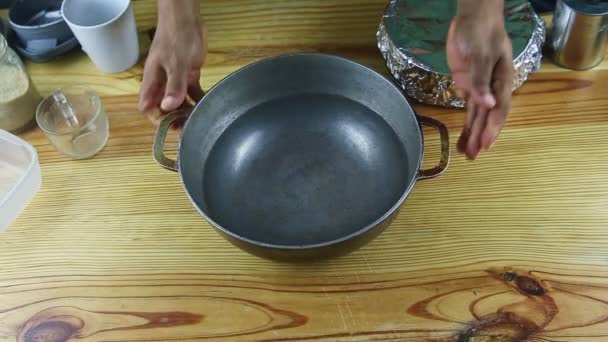 felső nézet az ember kézzel tesz nagy öntöttvas csészealj sima vízzel főzés - Felvétel, videó