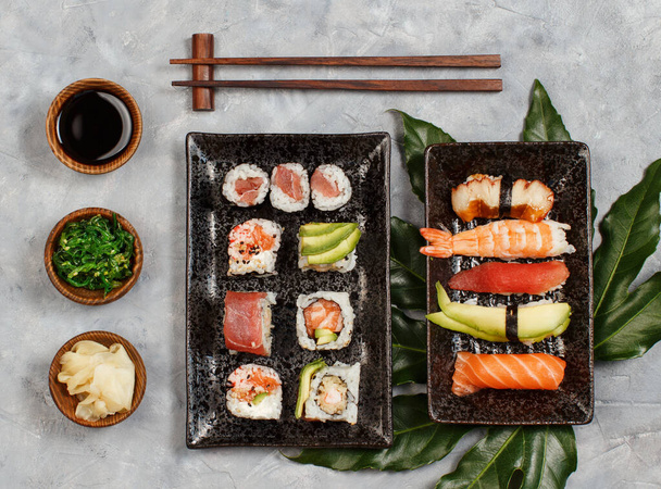 Sushi Állítsa nigiri és sushi tekercs téglalap alakú lemezek tetejére nézet - Fotó, kép