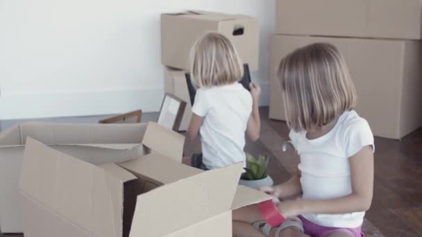 Roztomilé dívky vybalování věcí v novém bytě - Záběry, video