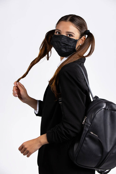 Caucasian girl with the leather bag holds her hair and looks at the camera - Photo, Image