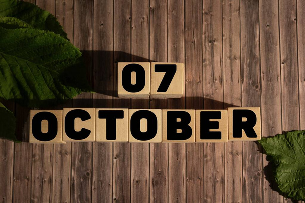 7 жовтня. 7 жовтня на дерев'яних кубиках на дерев'яному тлі. Осінь. Календар на жовтень
. - Фото, зображення
