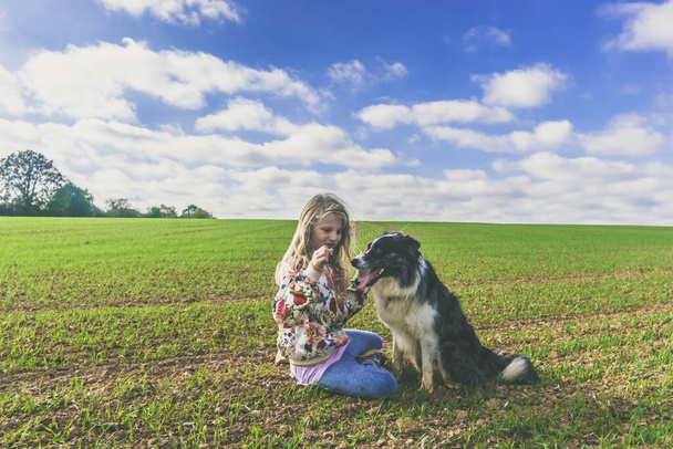 дружба дівчини і собаки в красивому сільському пейзажі
 - Фото, зображення