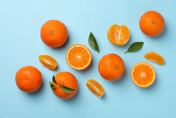 Ripe sweet mandarins on blue background, top view - Zdjęcie, obraz