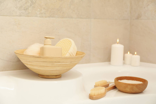 Bath with personal hygiene accessories in light beige bathroom - Photo, Image