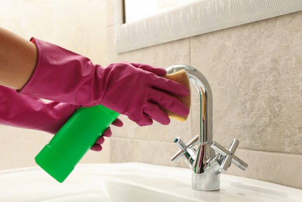 Woman in rubber pink glove cleaning sink - Фото, зображення