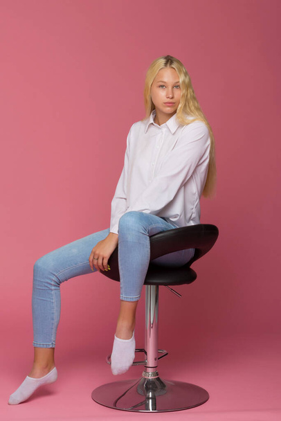 Cute Smiling Blonde Girl Sitting on High Chair in Studio - Fotó, kép