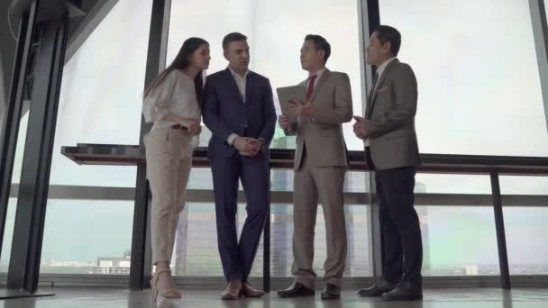 Aziatische en Kaukasische zakenmensen schudden elkaar de hand om in te stemmen met een zakelijke deal. - Video