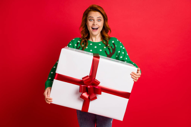 Photo portrait of excited girl holding giant white wrapped box isolated on bright red colored background - Fotografie, Obrázek