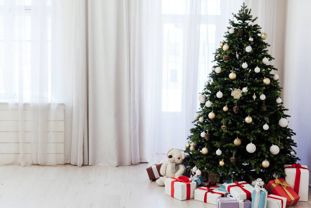 Winter-Weihnachtsbaum mit Geschenken Neujahr Dekor Girlanden Innenraum des Ferienhauses Dezember - Foto, Bild