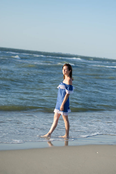 Karadeniz kıyısındaki bir kadın. Sahilde makyajsız poz veren bir model. Yaz tatili kavramı - Fotoğraf, Görsel