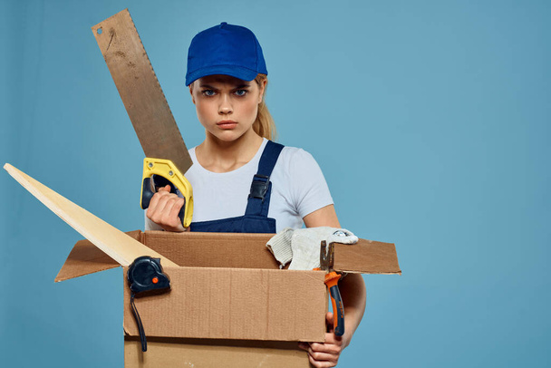 宅配サービスをロードする手のツールでボックスと制服を着た働く女性青の背景 - 写真・画像