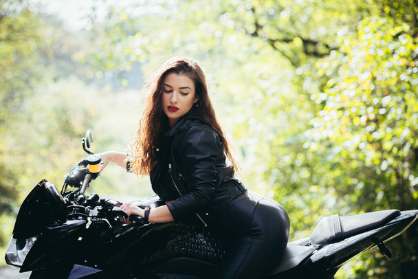 Biker sexy woman sitting on  motorcycle. Outdoor lifestyle portrait - Photo, image