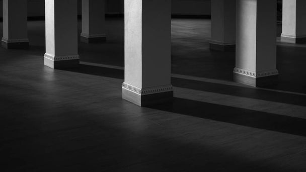 Base de pilares cuadrados grupo con luz solar y sombra en la superficie de piso de baldosas de madera en estilo blanco y negro, concepto de arquitectura interior - Foto, Imagen