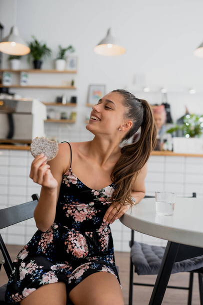 Happy smiling girl holds cookie in a cozy cafe. - Foto, Imagen