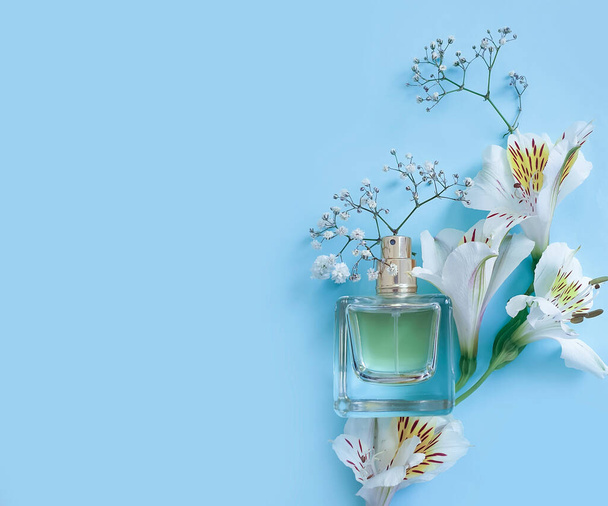 fles parfum bloem op een gekleurde achtergrond - Foto, afbeelding