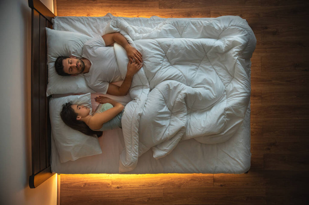 De man en een vrouw slapen op het bed. zicht van bovenaf - Foto, afbeelding