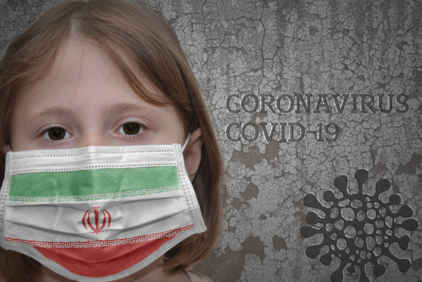 Dívka v lékařské masce s vlajkou Íránu stojí u staré vinobraní zdi s textem koronavirus, covid, a virus obrázek. Zastavit virus - Fotografie, Obrázek