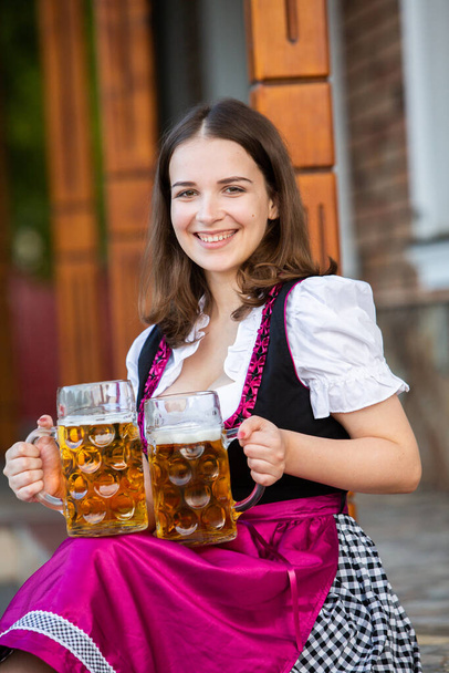Güzel Ekim Festivali kızı elinde bira kupaları olan geleneksel bir Bavyera elbisesi giyiyor. Biralı seksi Rus kadın.. - Fotoğraf, Görsel