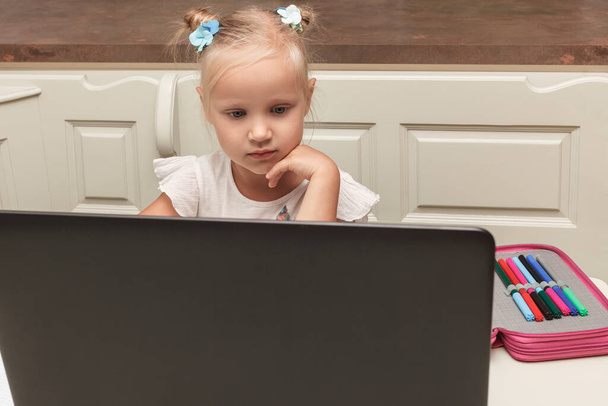 La bambina sta studiando a distanza su un portatile. Bambino e computer - Foto, immagini