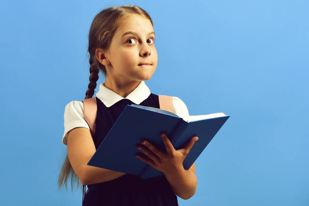 Back to school and education concept. Girl holds blue book - Foto, Imagem