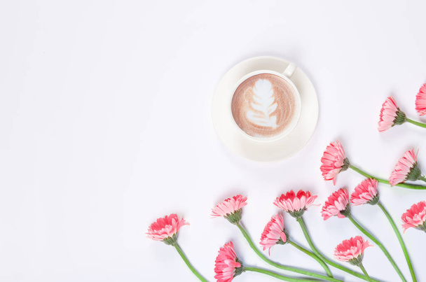 Coffee cup with latte art with pink flowers on white background - Foto, Imagen