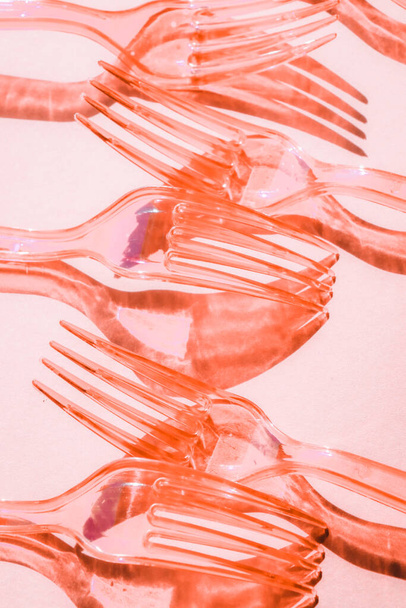 Αφηρημένη σύνθεση με σκιές από πλαστικό διάφανο πιρούνι σε ροζ φόντο - Φωτογραφία, εικόνα