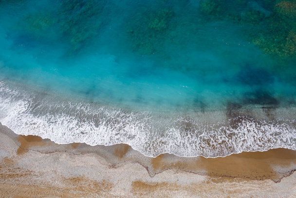 Vue de dessus de la côte de la mer avec eau azur et plage de sable. Photo aérienne de la mer Méditerranée avec le littoral. Belle mer en saison estivale, filmée depuis un drone - Photo, image