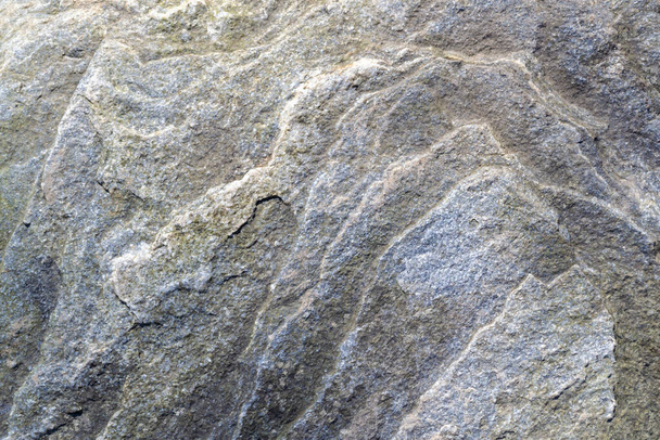 Uneven, rough, irregular granite stone surface. Natural textured relief grey background. - Photo, Image