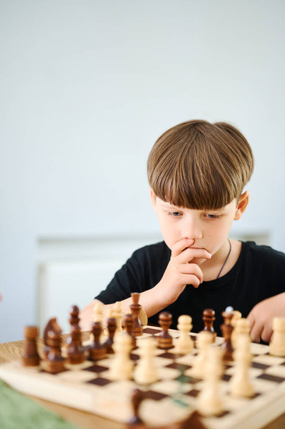 Inteligentny przedszkole kaukaski chłopiec gra w szachy w domu - Zdjęcie, obraz