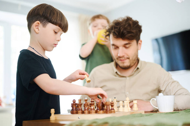 Padre che insegna al figlio a giocare a scacchi. Concetto di istruzione e insegnamento. - Foto, immagini