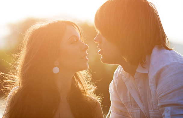 νέοι φιλιά στο ηλιοβασίλεμα - Φωτογραφία, εικόνα