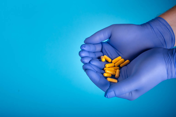 Doctor holding pills. Hands gloves with pills. Healthcare concept. High quality photo - Fotografie, Obrázek
