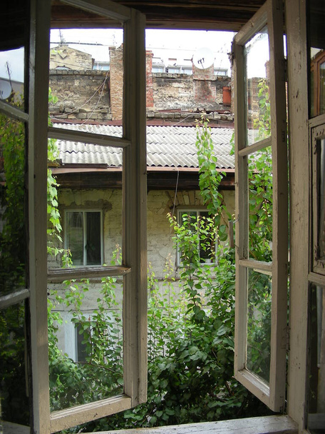 Unfavorable area of the city. View from the window of an abandoned house to the neighboring abandoned house. - Фото, изображение