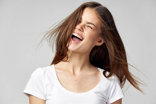 energetic woman with closed eyes opened her mouth wide and white t-shirt - Фото, изображение
