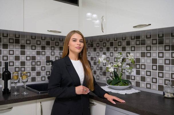 Lüks, modern, siyah-beyaz mutfak dekorasyonunda genç bir kadın. - Fotoğraf, Görsel