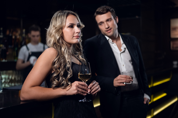 charming girl and handsome man with cocktail glasses in a nightclub - Фото, зображення