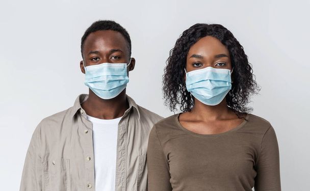 Pareja afroamericana que usa máscaras médicas protectoras para protección - Foto, Imagen