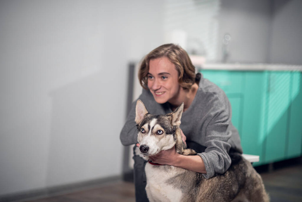 Gülümseyen bir kız veteriner kliniğinde köpeğine sarılıyor. Bir resim için poz veriyorlar. - Fotoğraf, Görsel