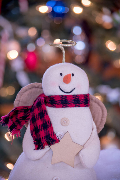 zblízka anděl sníh muž v přední části osvětlené vánoční strom doma - Fotografie, Obrázek