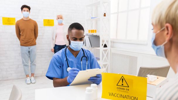 Médico trabajando con pacientes durante la campaña de vacunación contra el Coronavirus en el hospital - Foto, Imagen